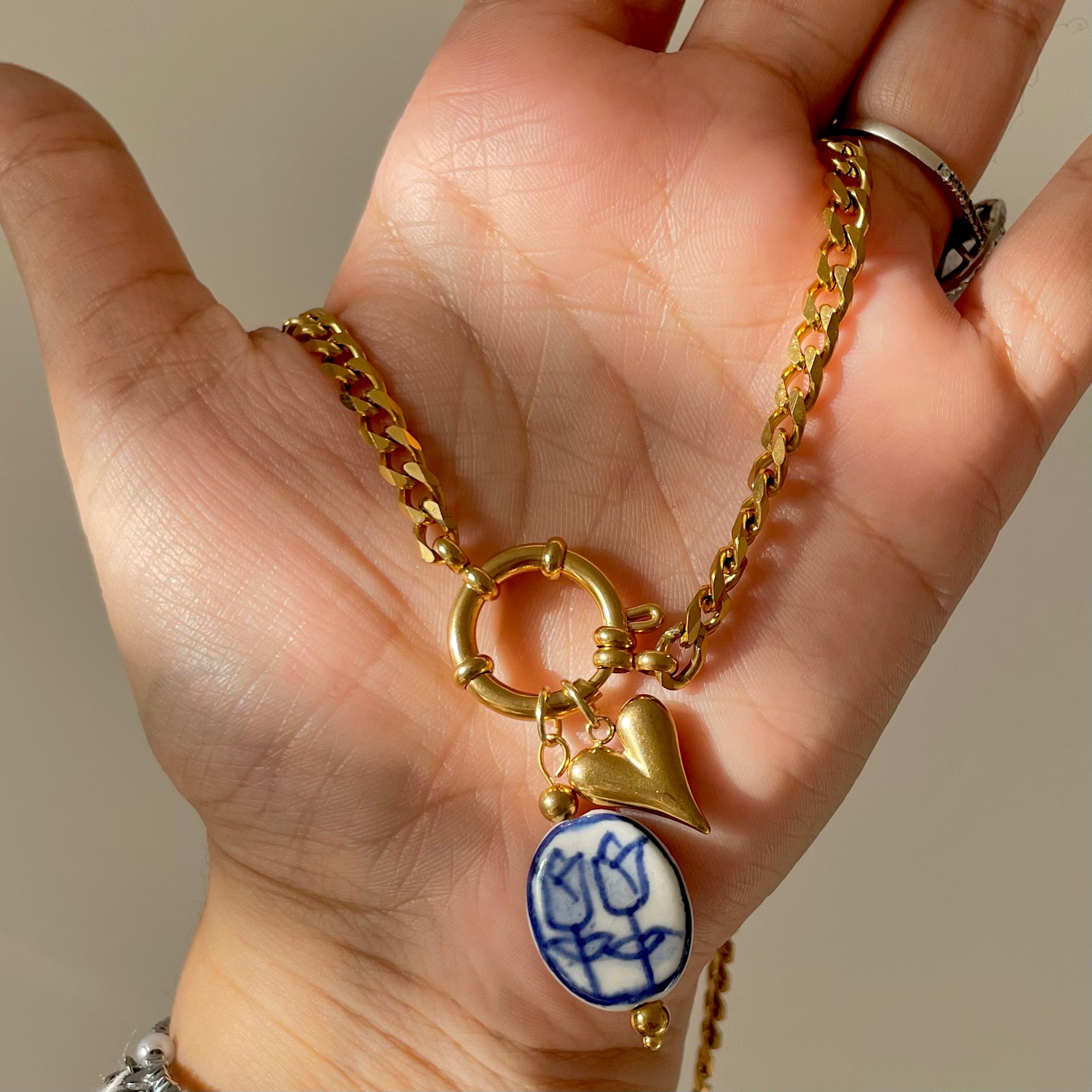Blue Floral Ceramic Bead Charm on a gold charm necklace