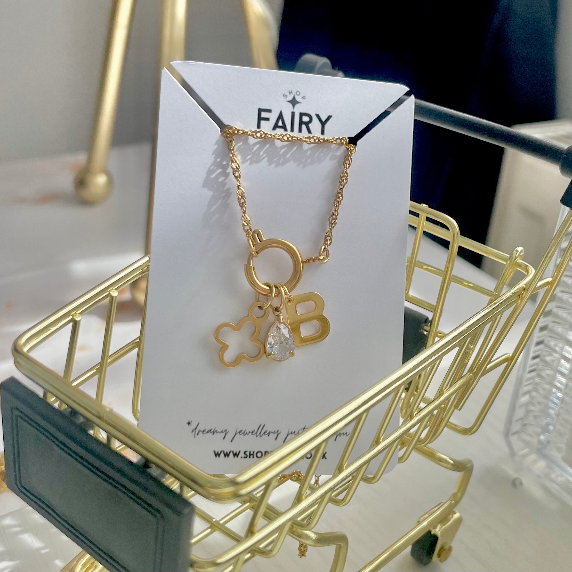 gold charm necklace with an initial charm