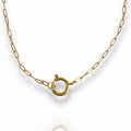A dainty gold-colored link charm necklace with a round clasp in the center for attaching charms.