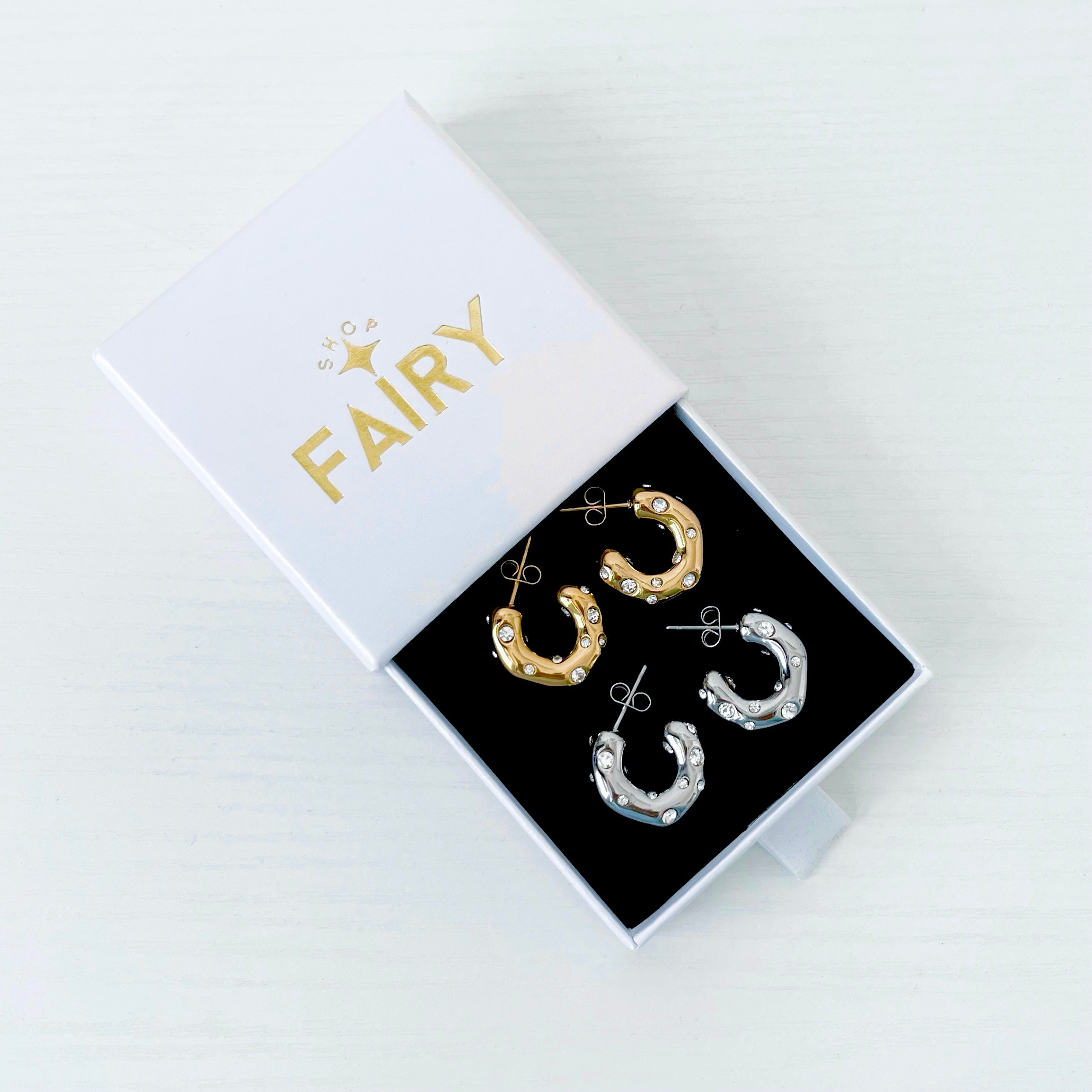 jewellery box featuring two pairs of hoops earrings - one pair gold with crystals and the other pair silver with crystals 