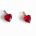 Two red crystal heart charms with silver and gold-colored settings, isolated on a white background.