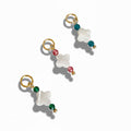 Three gold-colored metal charms featuring a clover design with one pearl and colored crystal beads in green, blue, and pink.