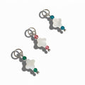 Three silver charms featuring clover pearl pendants with one green, one blue, and one pink bead attached to each.