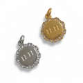 Two circular pendants, one gold and one silver, with '11:11' engraving on a white