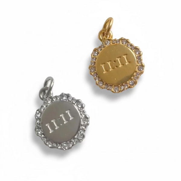 Two circular pendants, one gold and one silver, with '11:11' engraving on a white