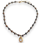 brown and gold beaded necklace
with gold oval bezel charm