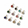 Gold pendants with colorful gemstones on a light background