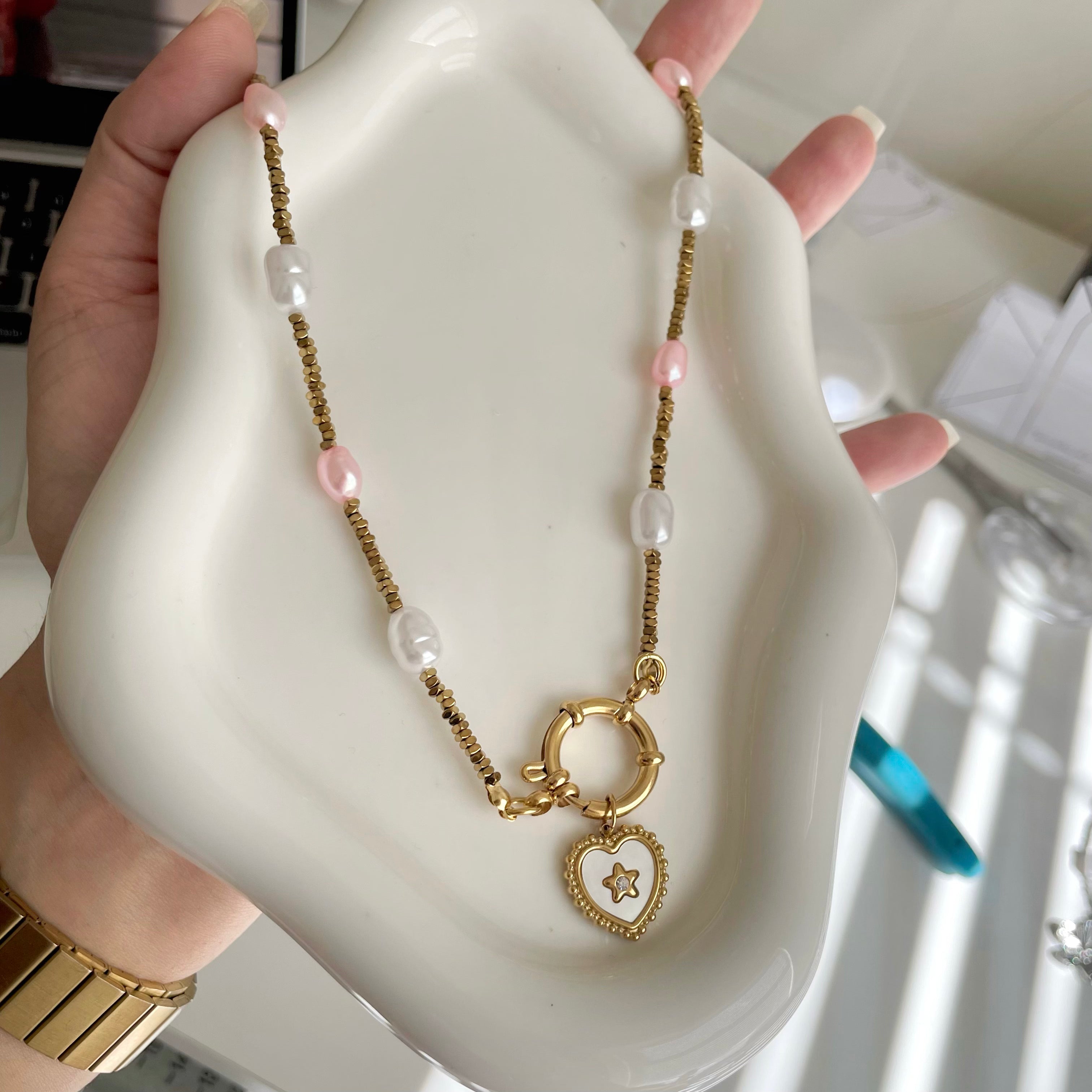 Necklace with a heart-shaped pendant held on a white dish