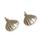 Pair of shell-shaped charms with gold and silver finish on a white background