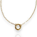 Gold necklace with a circular pendant on a white background