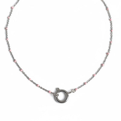 Necklace with pink beads and silver clasp on a light gray background