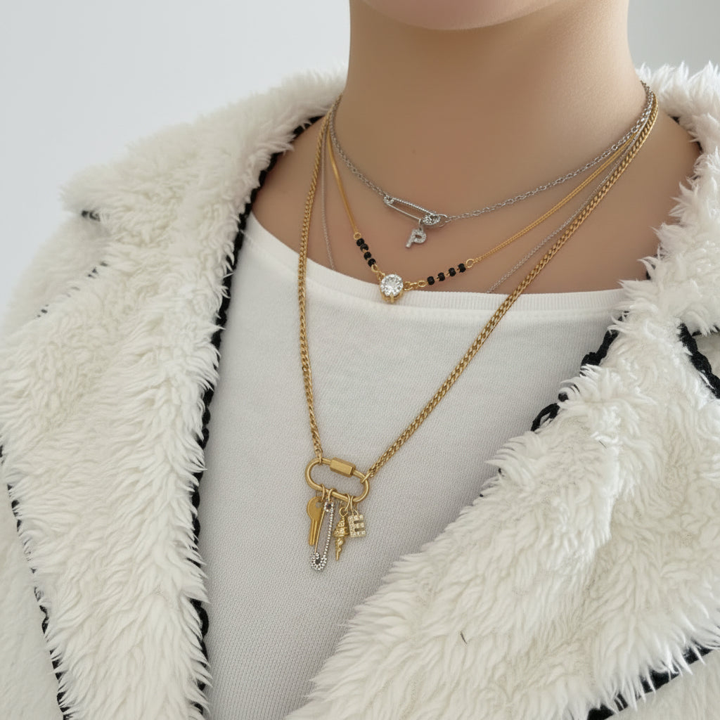 Gold necklace with charms on a white fabric background