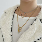 Gold necklace with charms on a white fabric background