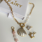 Gold necklace with charms on a white surface