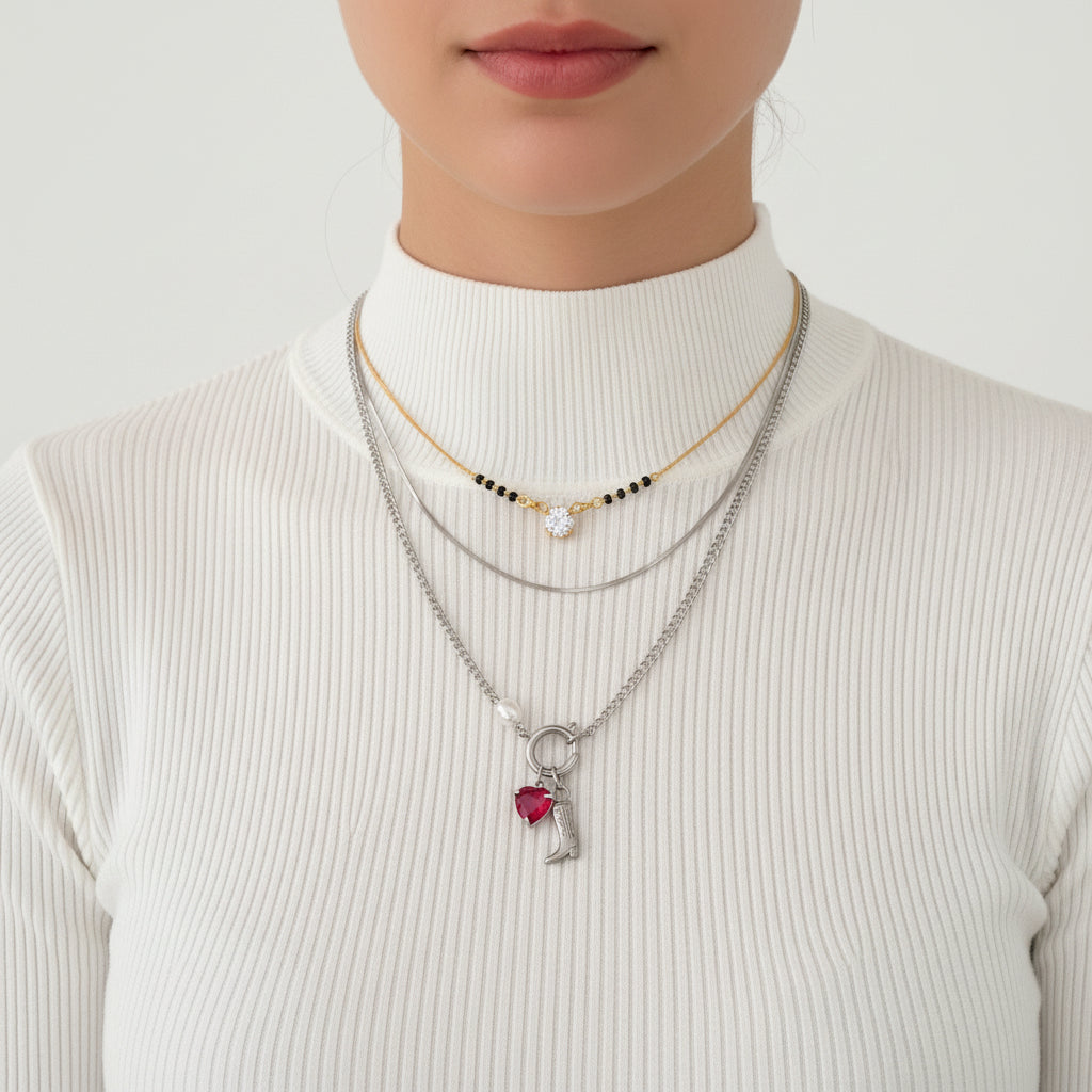 Necklace with a boot and heart charm worn by a person