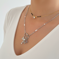 Silver necklace with a heart and butterfly pendant on a person wearing black lace lingerie.