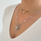 Silver necklace with a heart and butterfly pendant on a person wearing black lace lingerie.