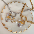 Two necklaces with charms on a decorative stone surface