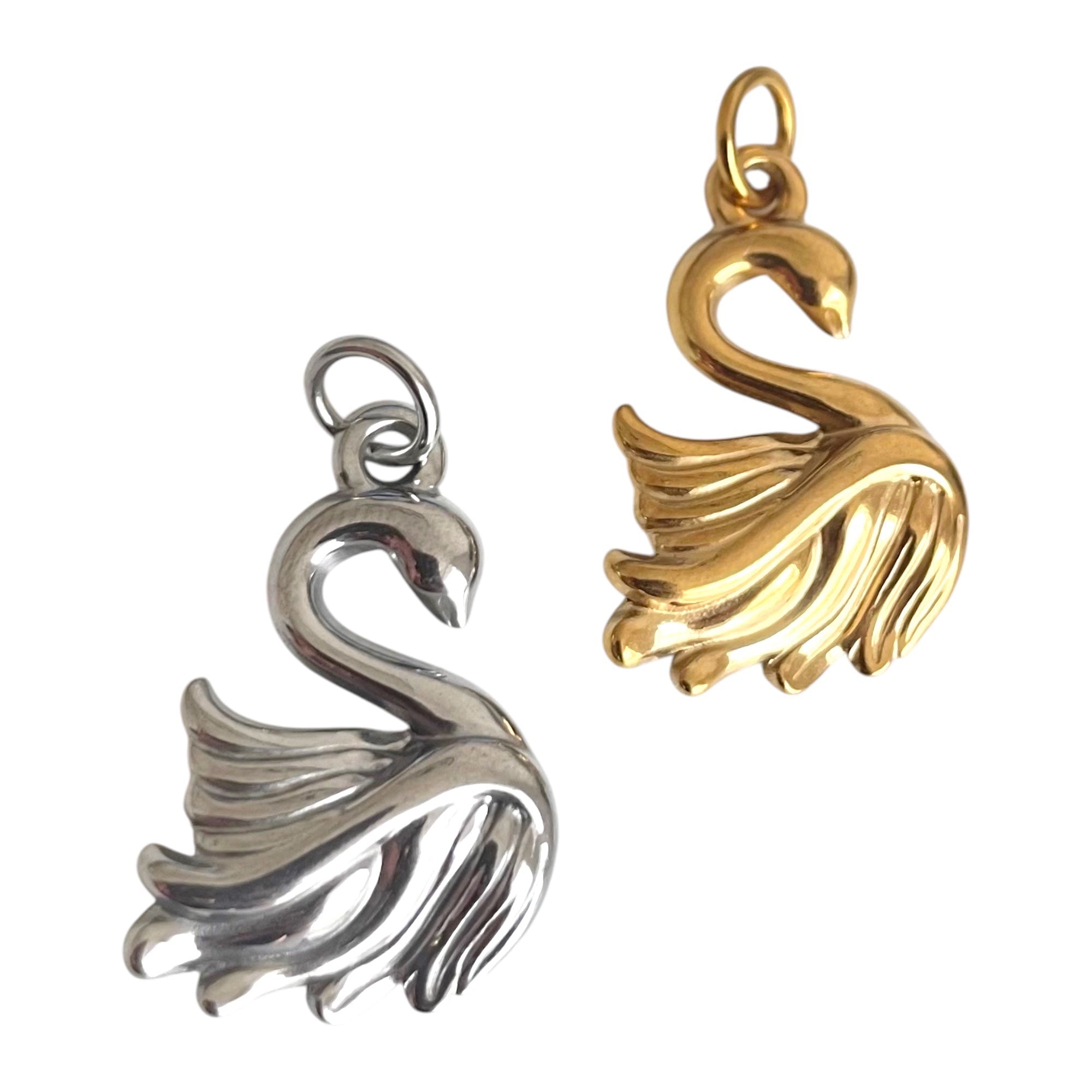 Gold and silver swan-shaped pendants on a white background